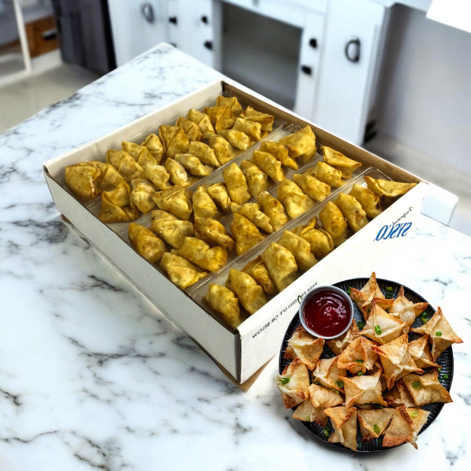 A Sysco Crab Rangoon Appetizer case rests on a marble countertop next to mini samosas and fried snacks with red sauce—ideal frozen appetizers for busy commercial kitchens.