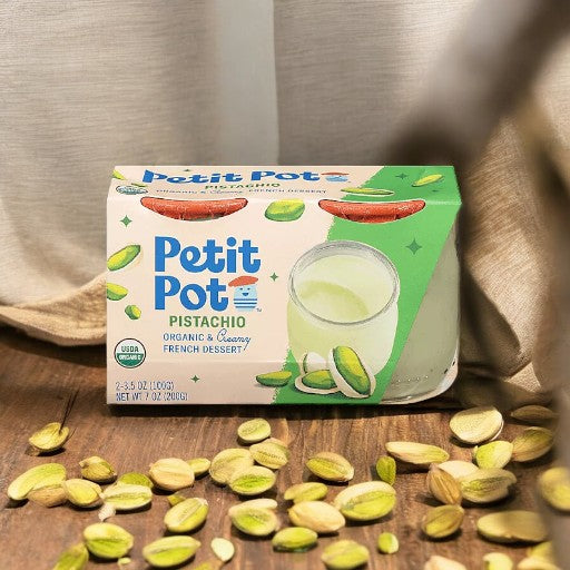 A box of Petit Pot Pistachio Organic French Dessert - 2 Petit Pots, surrounded by scattered pistachio shells and nuts, showcasing a taste of artisanal French cuisine.