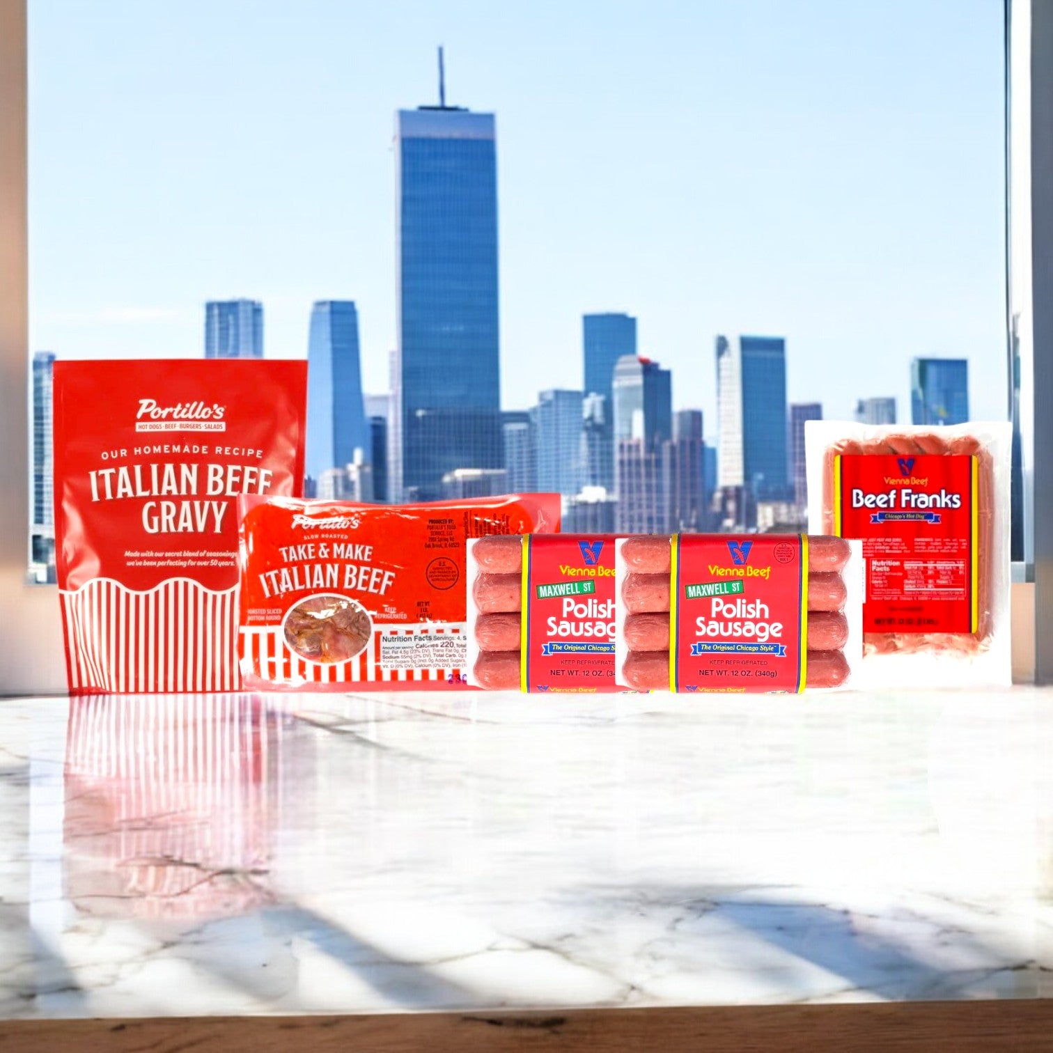 A view of a city skyline reveals a foreground table featuring Easy Lunches' Vienna Beef and Portillo's 3-Pack Combo: 8 Franks, 8 Polish Sausages, and Portillo's Italian Beef Gravy!.