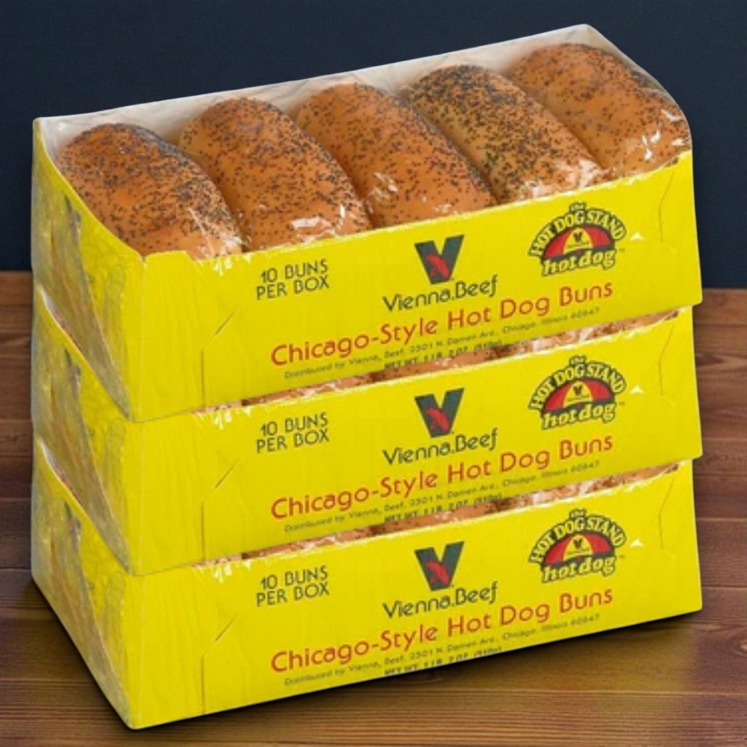 Three boxes of Vienna Beef Hot Dog Kit – 25 Franks, Poppy Seed Buns, Mustard & Relish are stacked on a wooden surface.