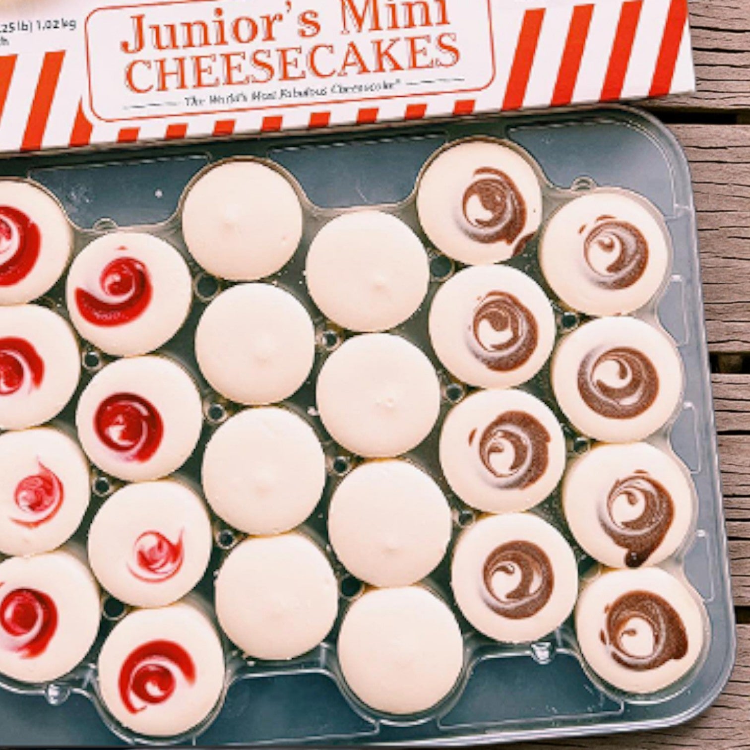 Enjoy the Junior’s & Member’s Mark Mini Cheesecake Combo Pack by Easy Lunches—an assortment of plain, chocolate swirl, and strawberry swirl mini cheesecakes in a clear container, perfect for any occasion.