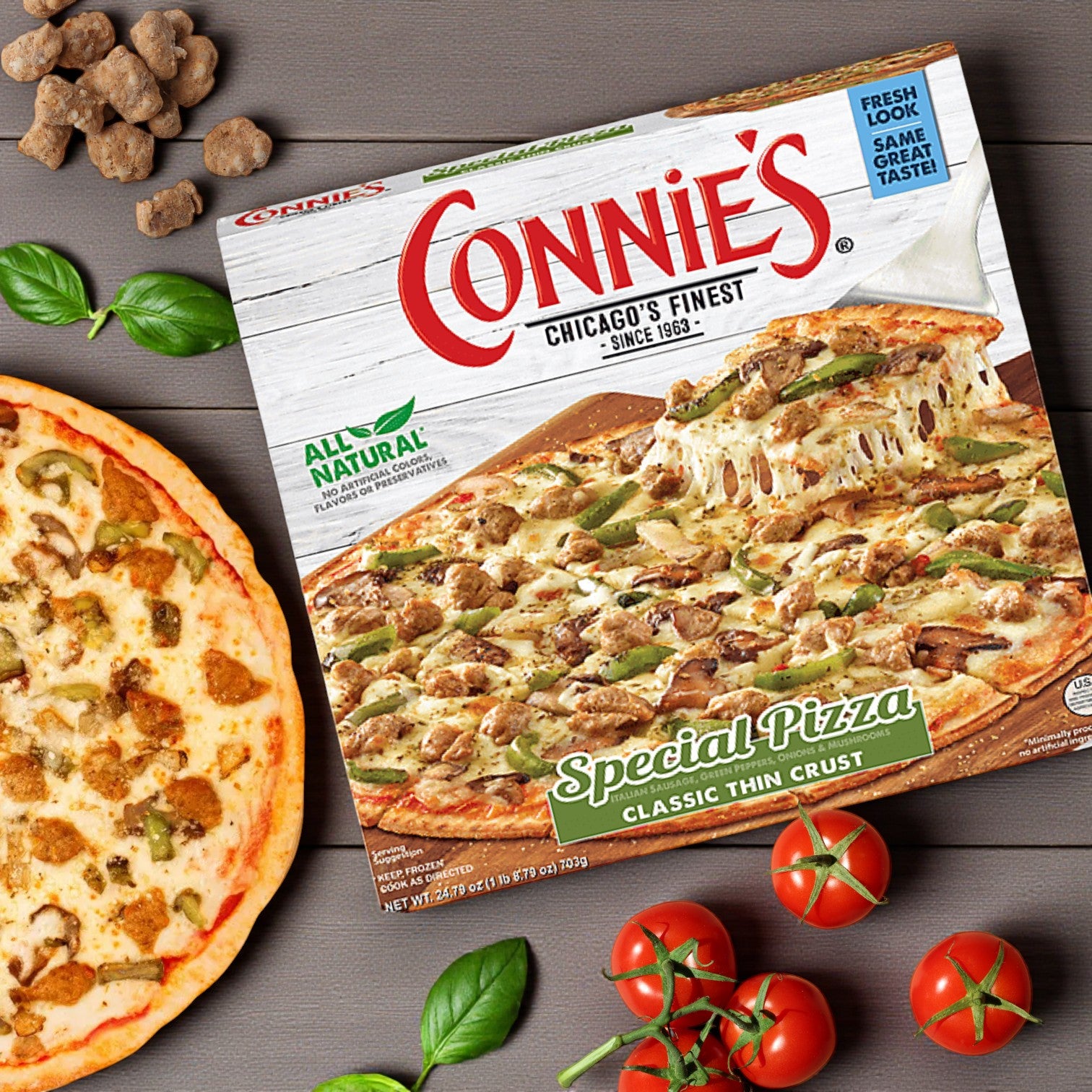 A Chicago's Best – Iconic Eats from the Windy City box and a baked pizza from the Chicago Pizza Lovers Combo! (includes 3 iconic pizzas) are shown on a wooden surface with fresh basil and tomatoes.