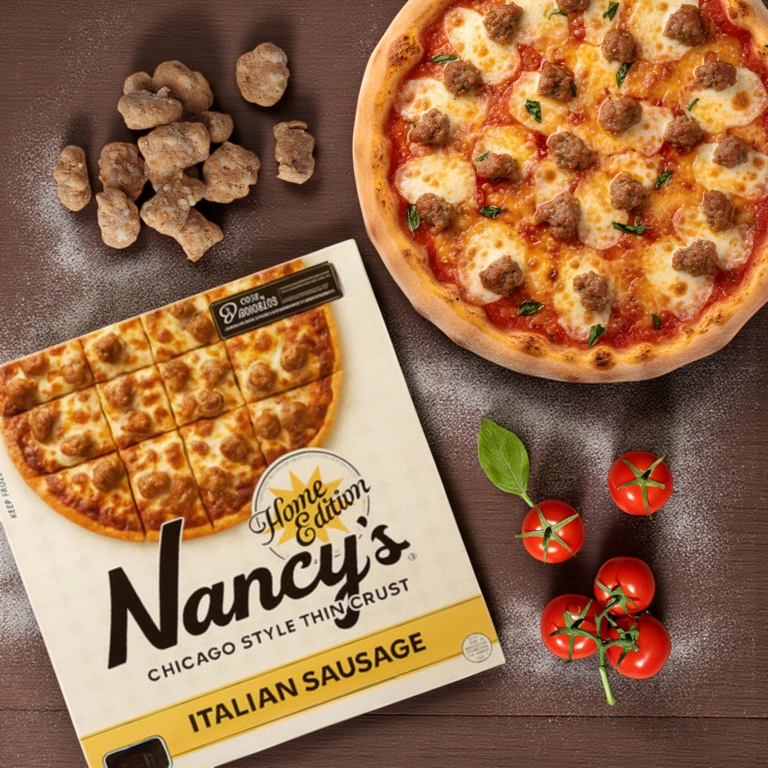 A Chicago's Best – Iconic Eats from the Windy City "Chicago Pizza Lovers Combo! Includes 3 Iconic Pizzas" sits next to its box, raw sausage pieces, and fresh tomatoes on a wooden surface.