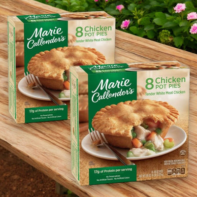 Two boxes of Easy Lunches' Marie Callender's Chicken Pot Pies rest on a wooden surface, each containing eight pot pies with tender white meat chicken in green packaging. With a total of sixteen comforting pot pies, this delicious meal is sure to become a family favorite.