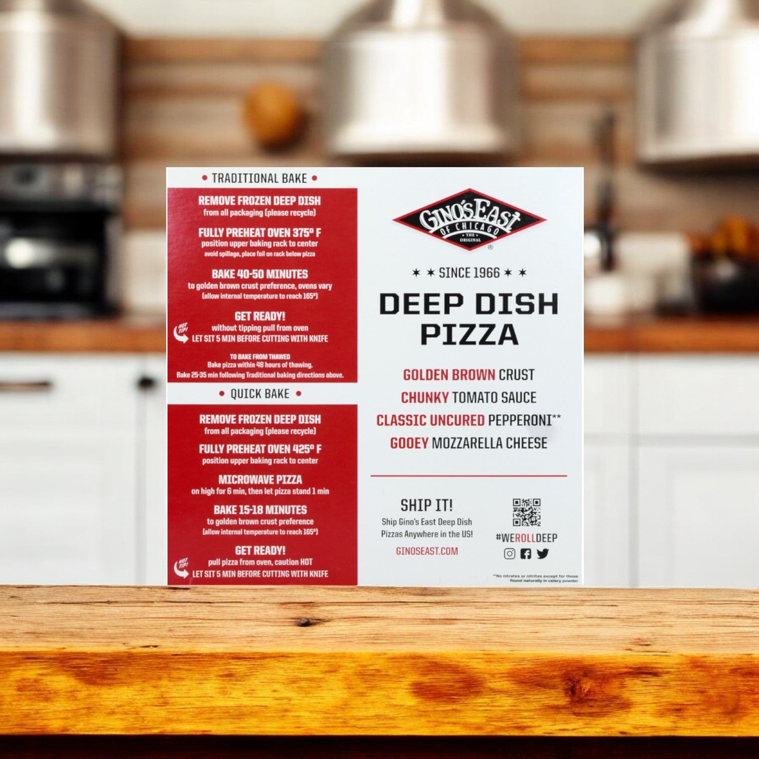 Sign on a kitchen counter with cooking instructions and details for Gino's East Uncured Pepperoni Deep Dish Pizza, highlighting their premium cheese blend. Background shows a blurred kitchen with stainless steel appliances and wooden cabinetry.