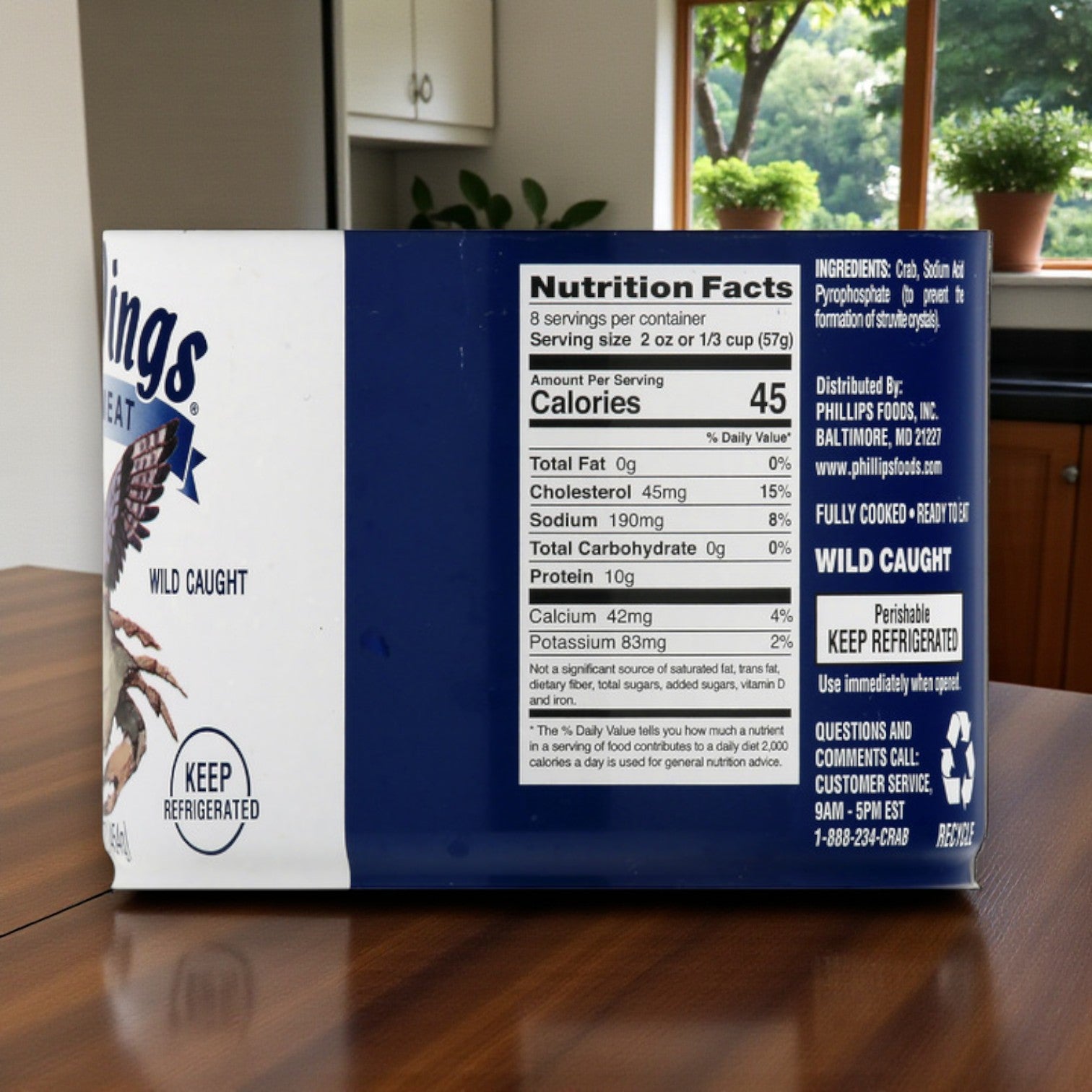 A case of Sea Wings Pasteurized Lump Crab Meat, 1 lb cans (6 count), is displayed on a kitchen counter, showing its nutrition facts and product label.