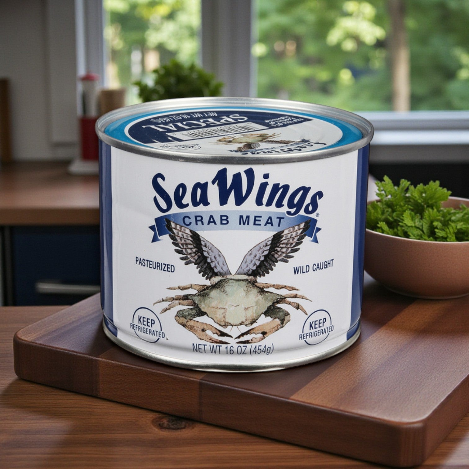 A 1 lb can of Sea Wings Pasteurized Special Crab Meat rests on a wooden cutting board in the kitchen, beside a bowl of fresh parsley—ideal for seafood stuffing or enhancing your favorite dishes.