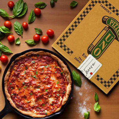 An Uno’s Deep Dish Cheese Pizza (MADE IN RESTAURANT) by Easy Lunches sits beside its box, topped with fresh basil and cherry tomatoes, next to Portillo’s Famous Chocolate Cake Frozen for dessert.