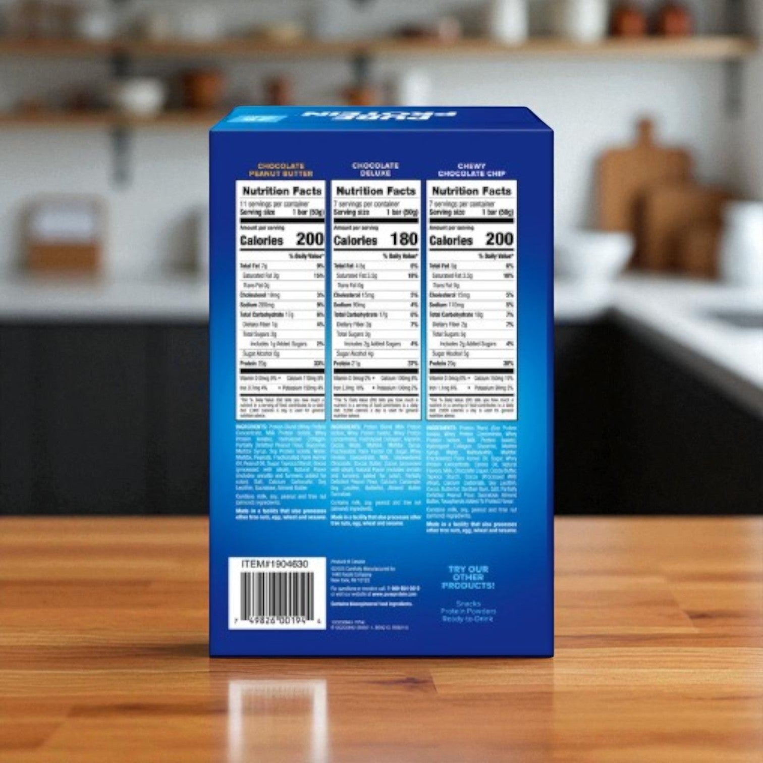 A blue box of Easy Lunches Pure Protein Bars, Variety Pack, 25-count, features three nutrition facts labels on the back and sits on a wooden kitchen counter. These high-protein bars make a perfect healthy snack anytime.