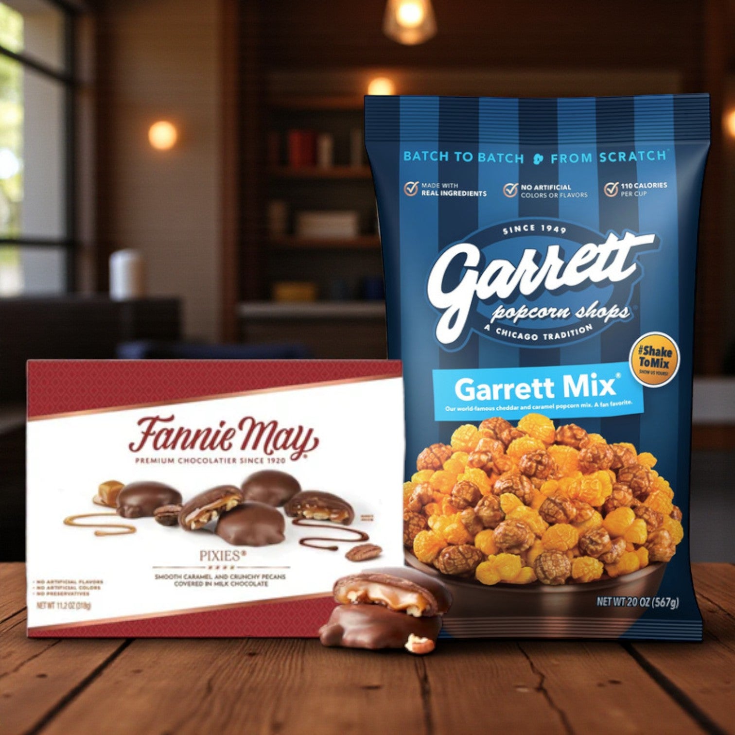 A box of Fannie May's Chicago Favorites Sweet & Savory Combo—featuring Pixies Chocolate and Garrett Popcorn Mix—is displayed on a table with a blurred background.