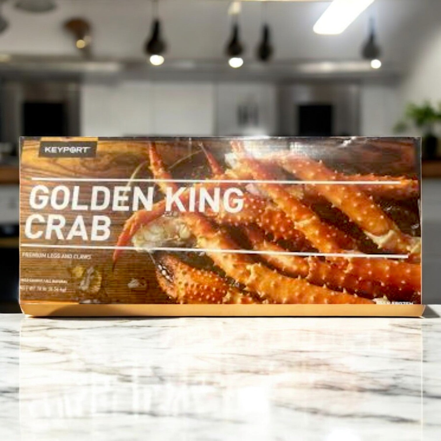 A 1-pound Keyport Golden Alaskan King Crabs pack, featuring premium legs and claws, is elegantly showcased on a marble countertop in a modern kitchen.