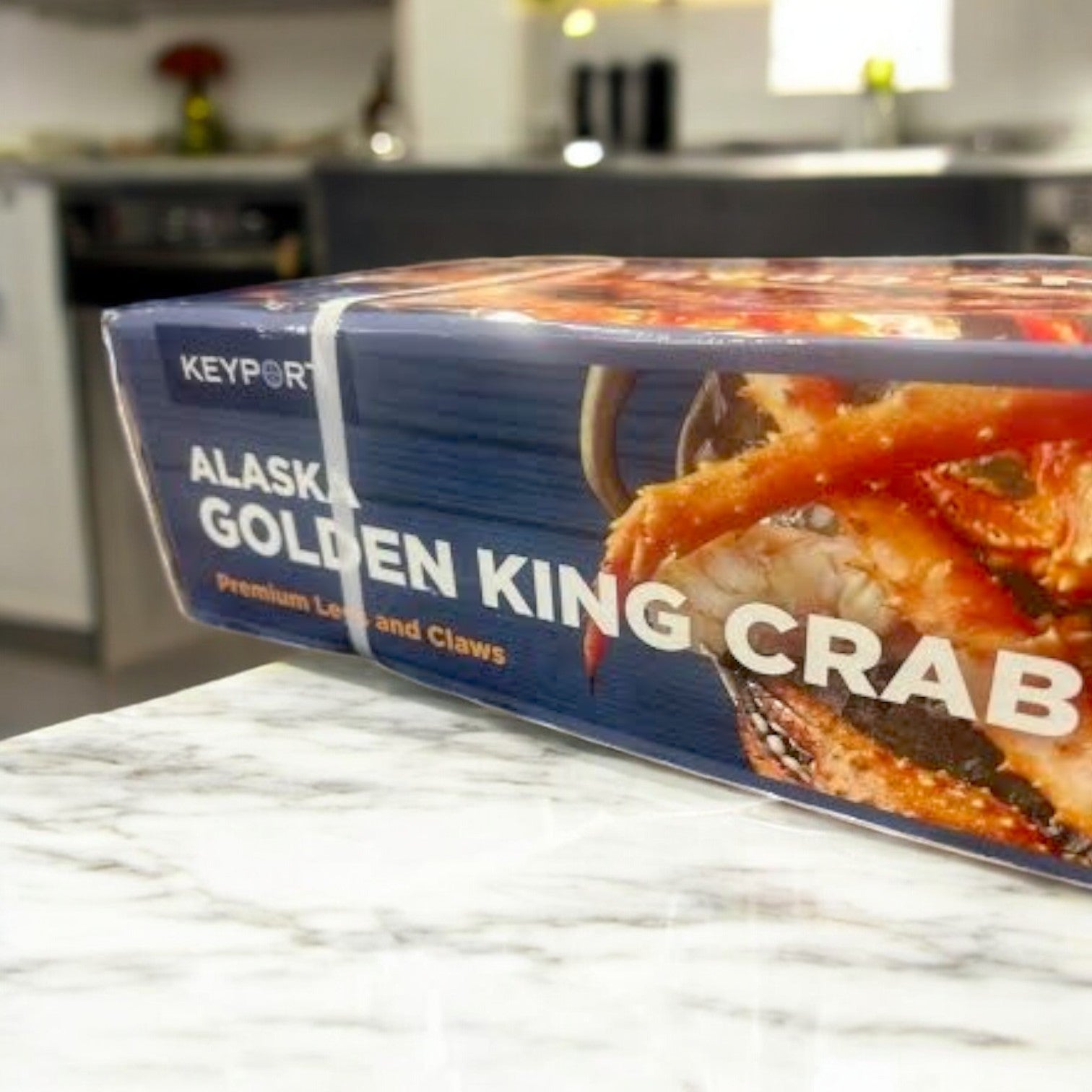 A 1-pound pack of Keyport Golden Alaskan King Crab legs and claws is displayed on a marble countertop, showcasing premium quality and sustainable sourcing.